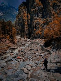 Man walking on rocks by mountain