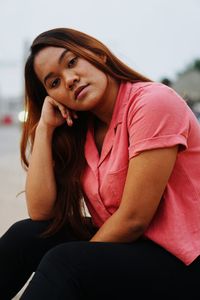 Portrait of beautiful young woman sitting outdoors