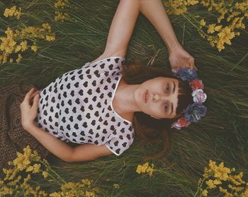 Portrait of young woman lying on field