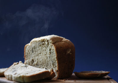 Close-up of bread on table against black background