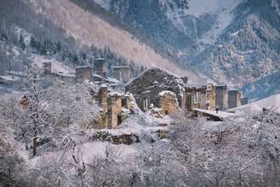 Aerial view of snow covered houses by mountain