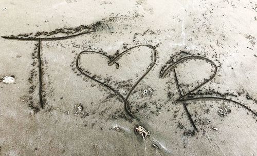 High angle view of heart shape on sand at beach