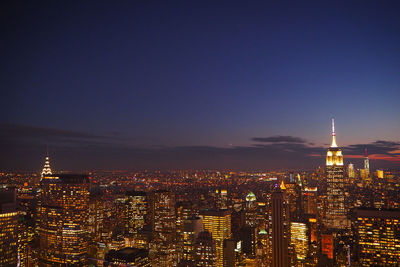 Illuminated buildings in city against sky at night