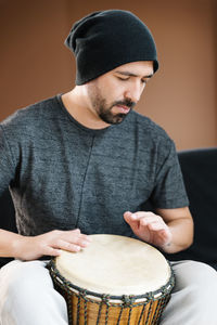 Man playing drum while sitting in studio