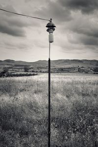 Electricity pylon on field against sky