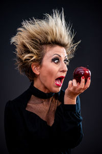 Portrait of woman against black background