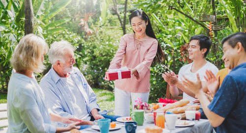 Cheerful family enjoying meal while sitting outdoors