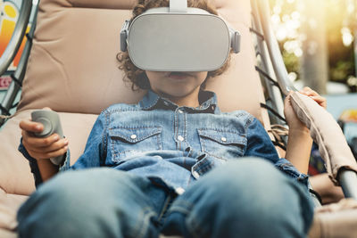 Rear view of boy using mobile phone