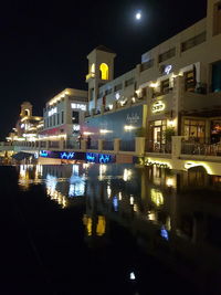 Illuminated city against sky at night