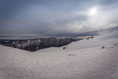 Scenic view of snow covered mountains against sky