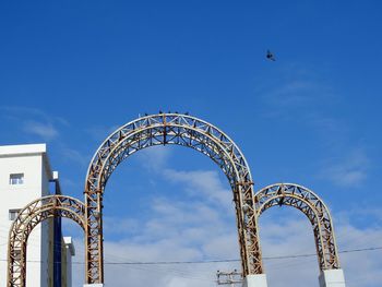 Low angle view of ferris wheel against blue sky