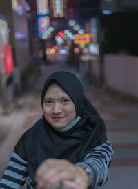 Portrait of smiling young woman standing outdoors