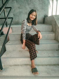 Portrait of happy young woman on staircase