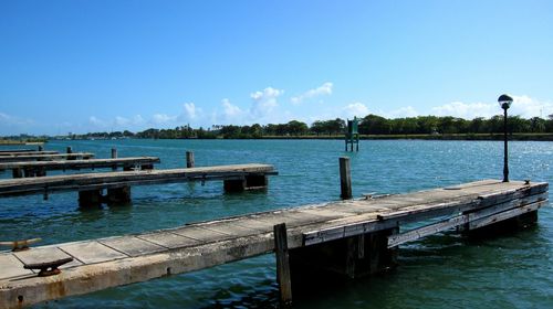 Pier over lake against blue sky