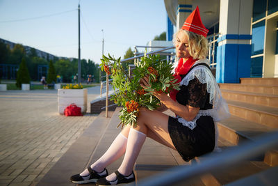 Full length of woman standing by fence