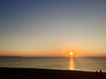 Scenic view of sea against clear sky during sunset