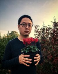 Portrait of young man holding flower