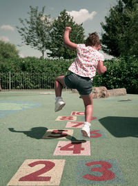 Full length of girl jumping on tree