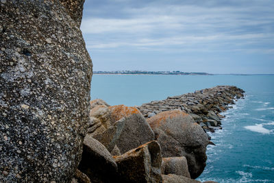 Rock formation on beach against sky