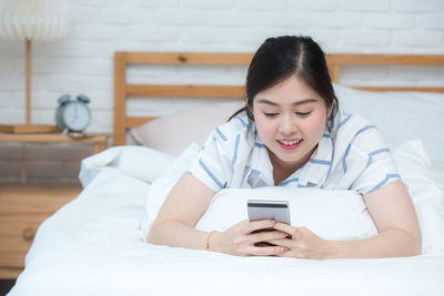 Young woman using mobile phone at home