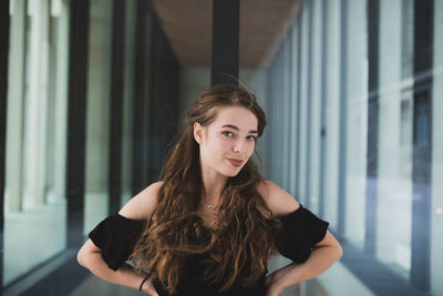 Portrait of young woman standing in building