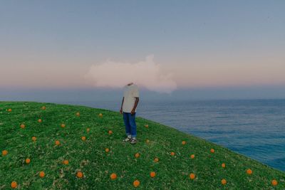 Rear view of man looking at sea against sky