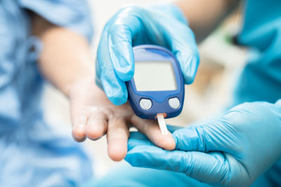 Midsection of doctor holding dental equipment