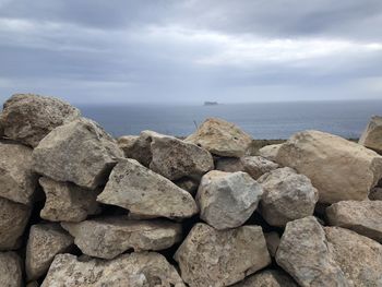 Rocks on sea shore against sky