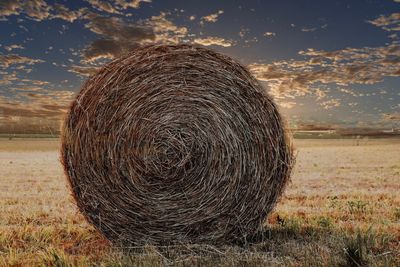 Hay bales on field against sky