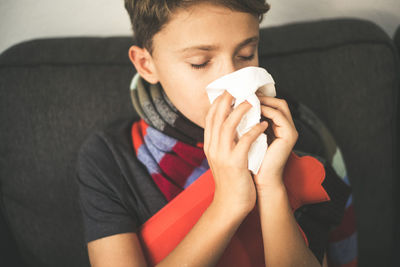 Close-up of boy blowing nose