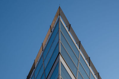 Low angle view of skyscraper against clear blue sky