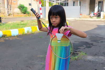 Girl playing badminton in the front house