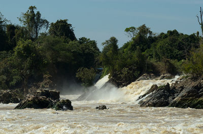 Scenic view of waterfall against sky