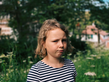 Portrait of girl standing against plants