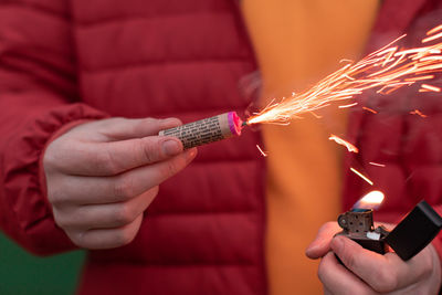 Close-up of person holding burning candle