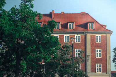 Residential building by trees against sky