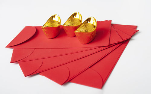 Close-up of red gift against white background