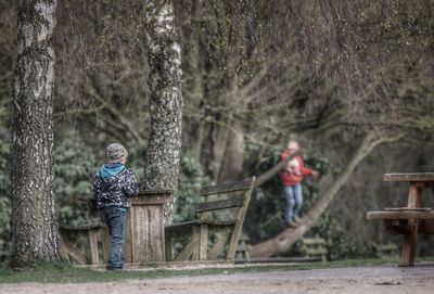 Boys playing on field in forest