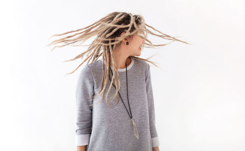 Woman with tousled hair standing against white background