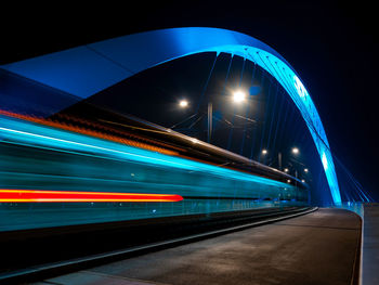 Lighted tram bridge at night. strasbourg. moving tram. passerell