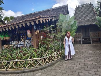 Woman with umbrella against building
