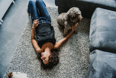 High angle view of woman and dog on floor