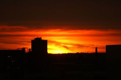 Silhouette buildings against sky during sunset