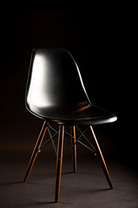 Close-up of empty chair against black background