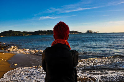 Rear view of woman looking at sea against sky