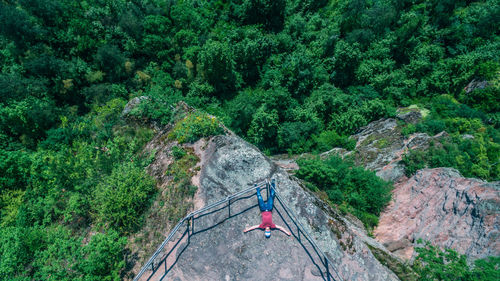 High angle view of man lying on rocky mountain