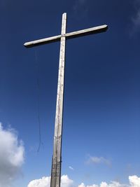 Low angle view of  summit cross against blue sky
