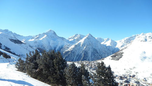 Scenic view of snowcapped mountains against clear blue sky