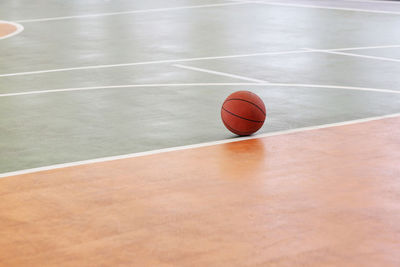 Basketball on floor in empty court