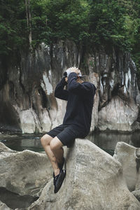 Young man sitting on rock